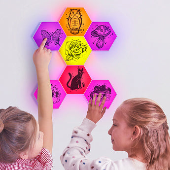 Two children interacting with colorful hexagonal light panels on a wall.