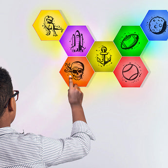 Person interacting with colorful hexagonal light panels on a wall